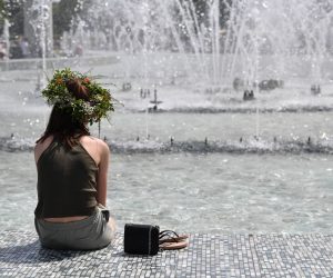 epa10022084 A woman sits at a water fountain as she attempts to cool off on a hot day in Fountains Park in Warsaw, Poland, 19 June 2022. Poland and large parts of Europe are going through a spell of hot weather. Temperatures in Warsaw were reported at 32 degrees Celsius.  EPA/RADEK PIETRUSZKA POLAND OUT