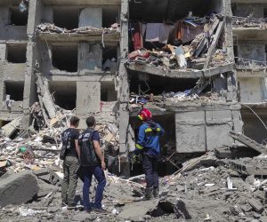 epa10045306 Prosecutor workers and rescuers stand at the scene of a damaged residential building after shelling hit the small town of Serhiivka near Odesa, southern Ukraine, 01 July 2022. At least 19 people were killed and 38 others injured, including six children, after overnight shelling hit a nine-story building and two holiday hotels in Serhiivka, Bilhorod-Dnistrovskyi district, Odesa region, the state emergency service said in a statement on 01 July.  EPA/STRINGER