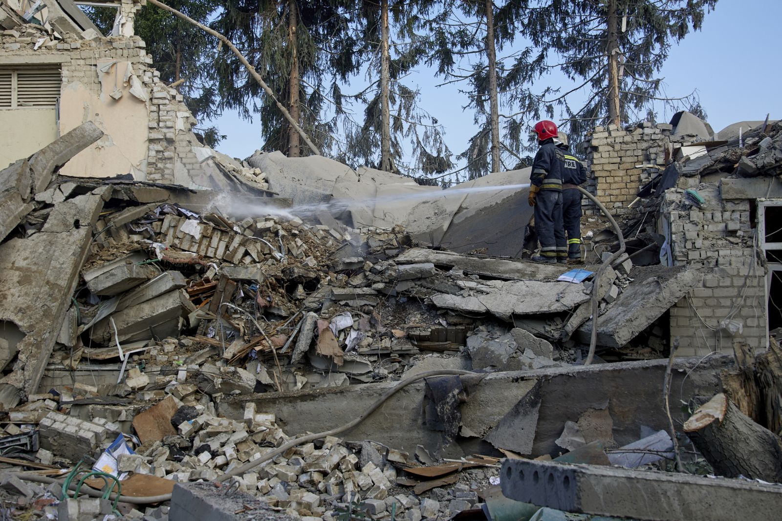 epa10051153 Ukrainian rescuers rest as they clean the debris at a school after a morning rocket shelling in a residential area of Kharkiv, Ukraine, 04 July 2022. Russian shelling destroyed a secondary school in Kharkiv and according to the head of the Kharkiv Regional Military Administration Oleh Synehubov there are no reports about casualties. Kharkiv and its surrounding areas recently have been the target of increased shelling and airstrikes by the Russian forces.  EPA/SERGEY KOZLOV