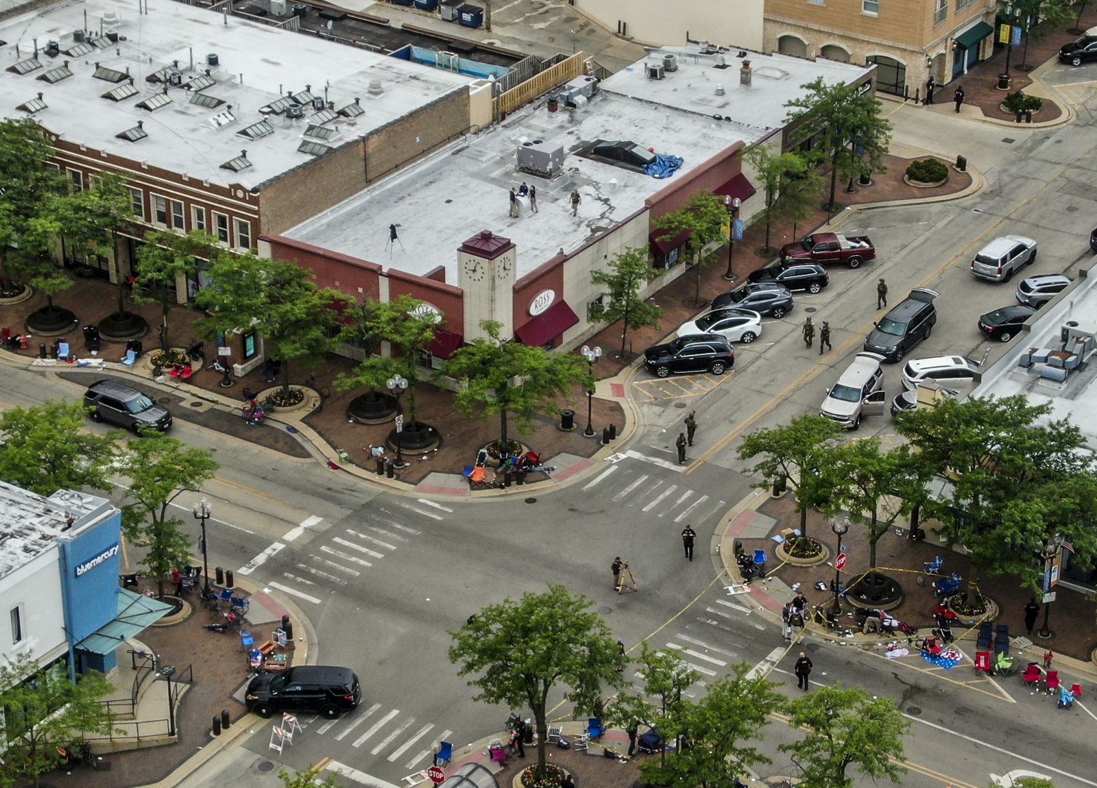 epa10052505 An aerial photo made with a drone shows law enforcement officers investigate the scene of a mass shooting at a 4th of July celebration and parade in Highland Park, Illinois, USA, 04 July 2022. A gunman opened fire as people gathered to watch a Fourth of July parade in Highland Park, Illinois, killing at least six people and injuring dozens.  EPA/TANNEN MAURY
