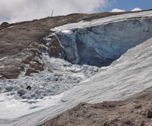 epa10052872 A photo taken from a helicopter shows the missing part of a glacier that collapsed on 03 July triggering an avalanche on the Marmolada Mountain in Canazei, Italy, 05 July 2022. At least seven people were killed and a dozen were still missing on 05 July after a glacier collapsed triggering an avalanche on the multi-peak mountain of the Italian Dolomites. The temperature on the glacier on 03 July was measured at a record of over 10 degrees Celsius.  EPA/ANDREA SOLERO