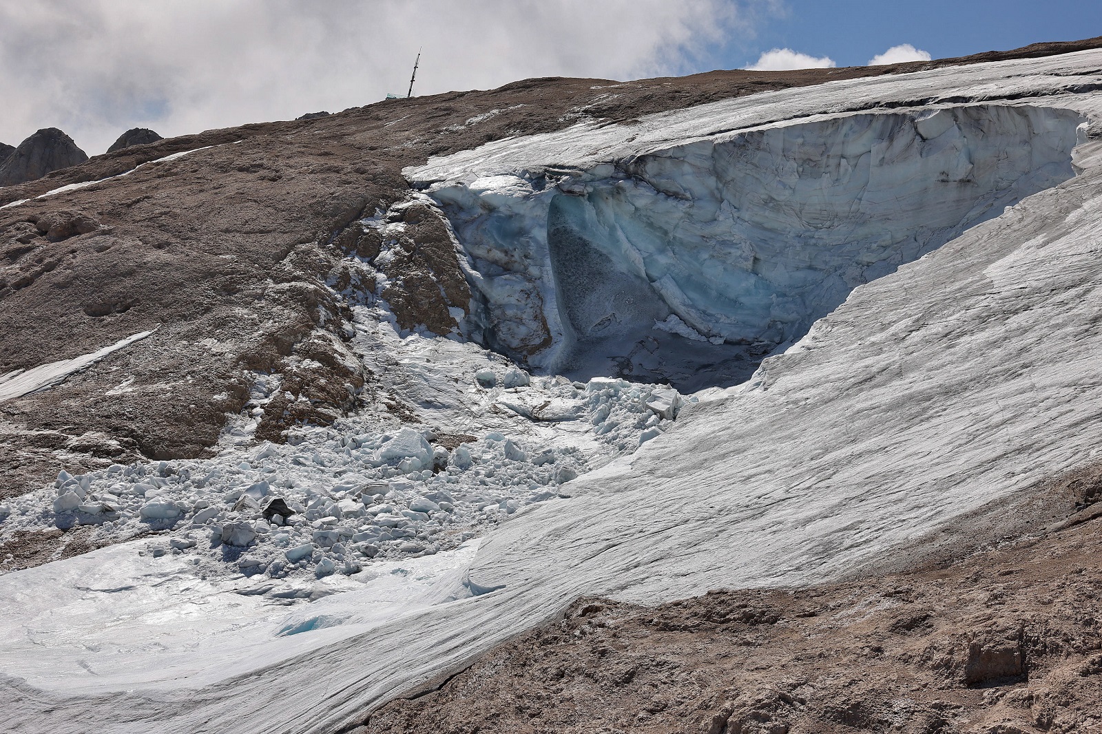 epa10052872 A photo taken from a helicopter shows the missing part of a glacier that collapsed on 03 July triggering an avalanche on the Marmolada Mountain in Canazei, Italy, 05 July 2022. At least seven people were killed and a dozen were still missing on 05 July after a glacier collapsed triggering an avalanche on the multi-peak mountain of the Italian Dolomites. The temperature on the glacier on 03 July was measured at a record of over 10 degrees Celsius.  EPA/ANDREA SOLERO