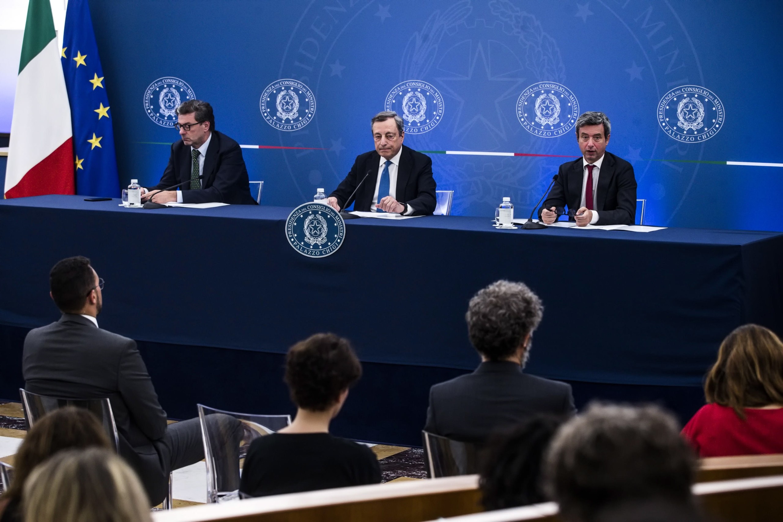 epa10067055 Italian Prime Minister Mario Draghi (C) with the Italian Minister of Labor Andrea Orlando (R) and Italian Minister of Economic Development, Giancarlo Giorgetti, during a press conference after the meeting with the CGIL, CISL, and UIL trade unions at the Multifunctional Hall of the Presidency of the Council, Chigi Palace, in Rome, Italy, 12 July 2022. Italian government proposed a new pact to trade unions to increase wages in order to help them through the inflation.  EPA/ANGELO CARCONI