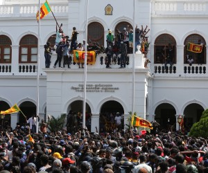 epa10068253 Protesters celebrate after they stormed the Prime Minister's office in Colombo, Sri Lanka, 13 July 2022. Thousands of protesters broke through police barricades and stormed into the Prime Minister's office on 13 July. Sri Lankan authorities declared a state of emergency and imposed a curfew in the Western Province of the country. According to the speaker of parliament, Sri Lankan President Gotabaya Rajapaksa has authorised the prime minister Prime Minister Ranil Wickremesinghe to carry out presidential duties after the president fled to the Maldives after months of protests against the economic crisis.  EPA/CHAMILA KARUNARATHNE