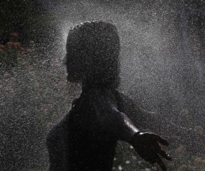 epa10074219 A woman cools off under sprinkrels in Cordoba, in Andalusia, Spain, 16 July 2022. Spanish state weather agency issued a red alert in five different communities -Aragon, Cantabria, Extremadura, Navarra and La Rioja- with temperatues reaching up to 44 degrees.  EPA/SALAS