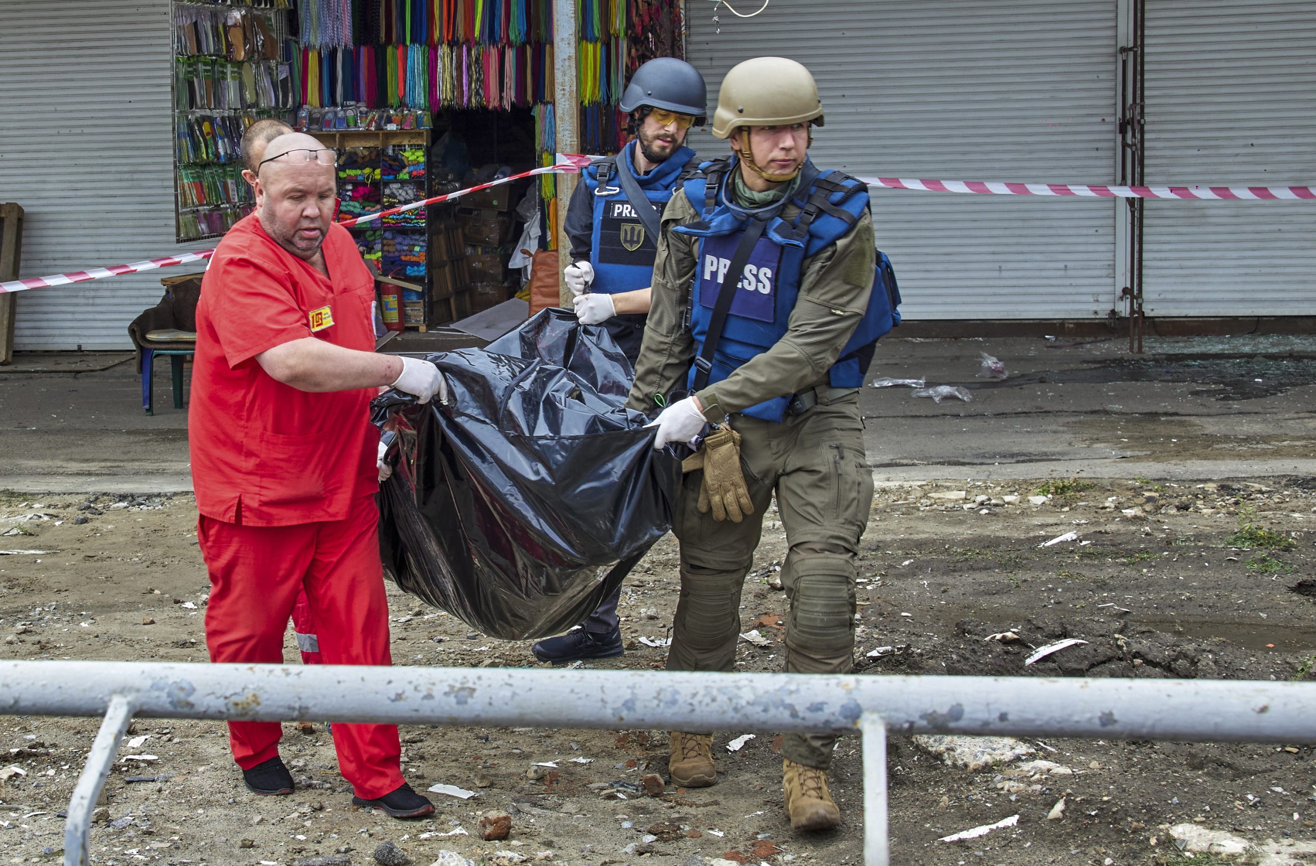 epa10084056 Medical workers and journalists carry the body of a victim following a Russian rocket strike hitting a bus stop near a market in Kharkiv, Ukraine, 21 July 2022. At least three people were killed and 23 injured in the attack, according to the Kharkiv's Regional Prosecutor's Office. Kharkiv and surrounding areas have been the target of heavy shelling since February 2022, when Russian troops entered Ukraine starting a conflict that has provoked destruction and a humanitarian crisis.  EPA/SERGEY KOZLOV