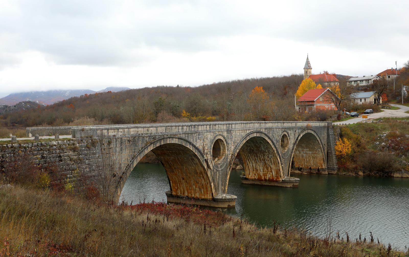 05.11.2021., Kosinj - Kosinjski most je kameni, sedamdeset metara dugi most preko rijeke Like koji spaja Gornji i Donji Kosinj. Izgraden je po uzoru na starohrvatsku mostogradnju, tehnikom uklinjenjem kamena. Projektirao ga je Milivoj Frkovic u 19. stoljecu, most je jedinstven i po otvorima u lukovima koji imaju funkciju rasterecenja vodenog vala pri udaru na most, a u vodi se ocrtavaju kao pravilni krugovi.
 Photo: Kristina Stedul Fabac/PIXSELL
