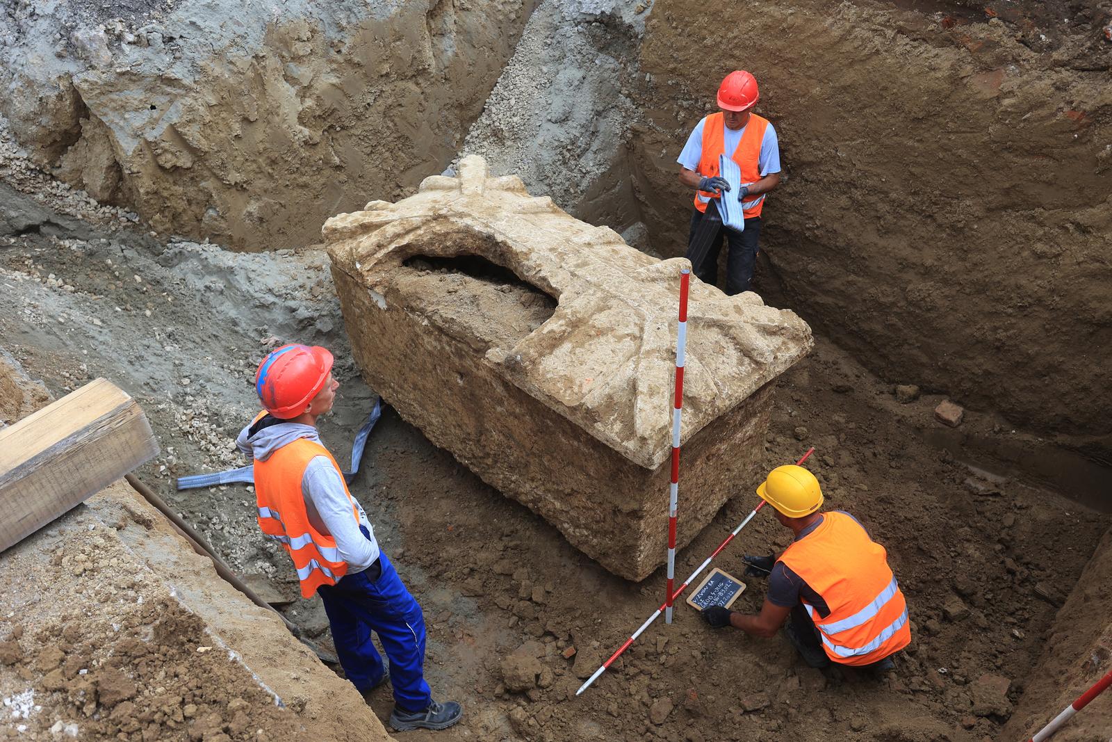 11.07.2022.,Vinkovci - Kameni sarkofag iz rimskog doba pronadjen je tijekom gradjevinskih radova u Zvonarskoj ulici u Vinkovcima. Kopajuci u sklopu radova na aglomeraciji u Vinkovcima, radnici su ispod ceste u Zvonarskoj ulici uocili bocni dio rimskog sarkofaga.Sarkofag je danas izvadjen i otvoren. Kako se i ocekivalo, unutra nema nista. Naime, sarkofag je razbijen, pretpostavlja se jos u anticko doba, te opljackan. Photo: Davor Javorovic/PIXSELL