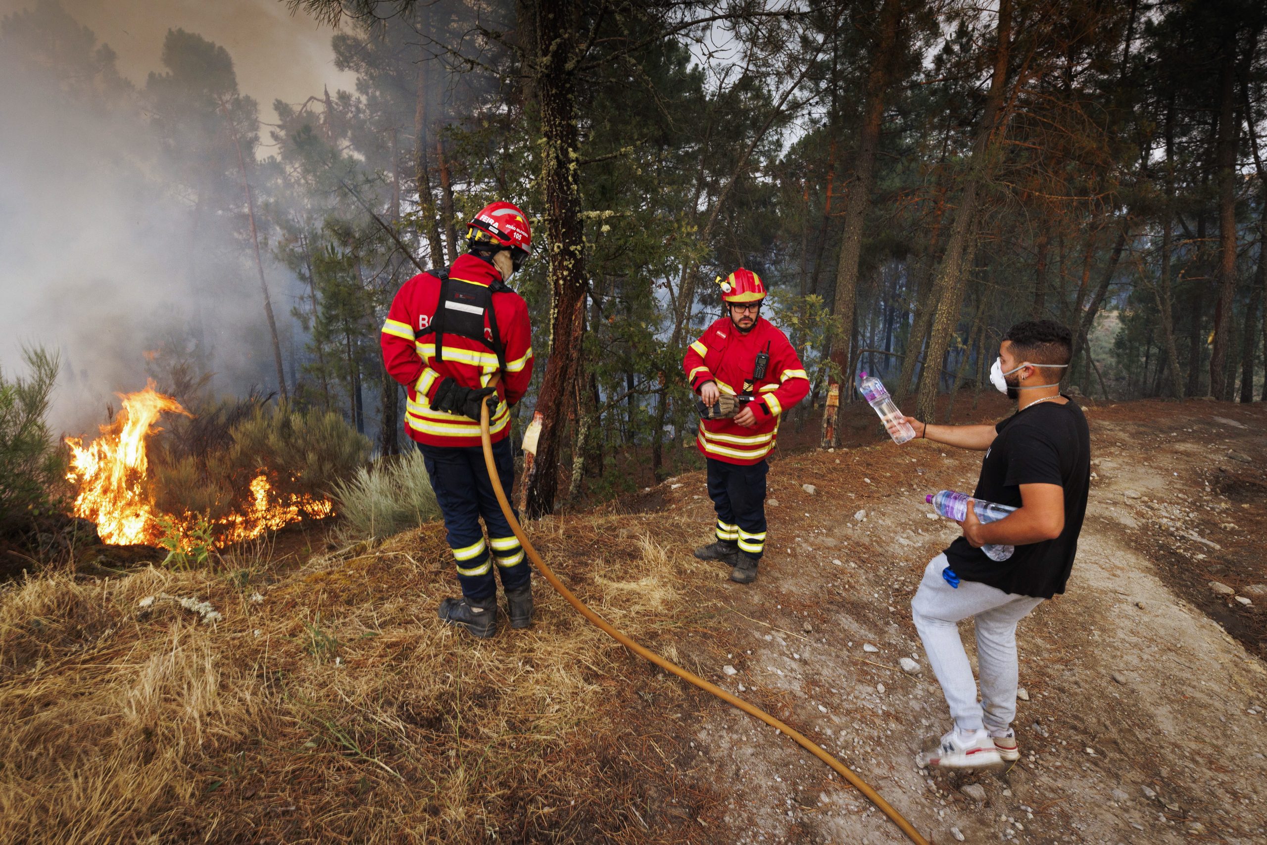 epa10096487 Firemen fights a forest fire in Reboredo village, Vila Pouca de Aguiar, Portugal, 28 July 2022. A total of 466 operational, 144 vehicles and six airplane are fighting the forest fire.  EPA/PEDRO SARMENTO COSTA