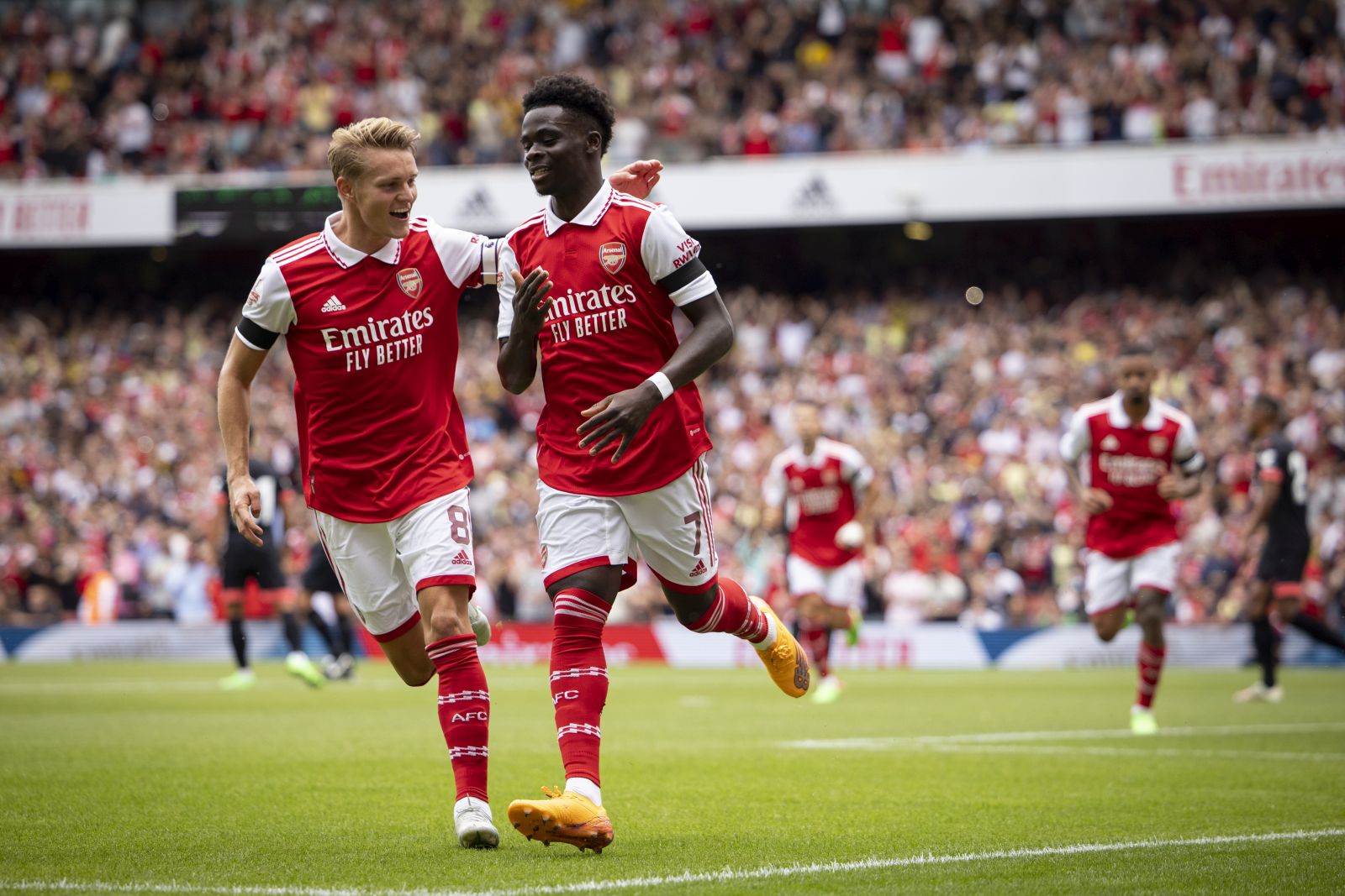 epa10098514 Bukayo Saka of Arsenal (R) celebrates after scoring the first goal of Arsenal during the Emirates Cup soccer match between Arsenal FC and Sevilla FC in London, Britain, 30 July 2022.  EPA/TOLGA AKMEN