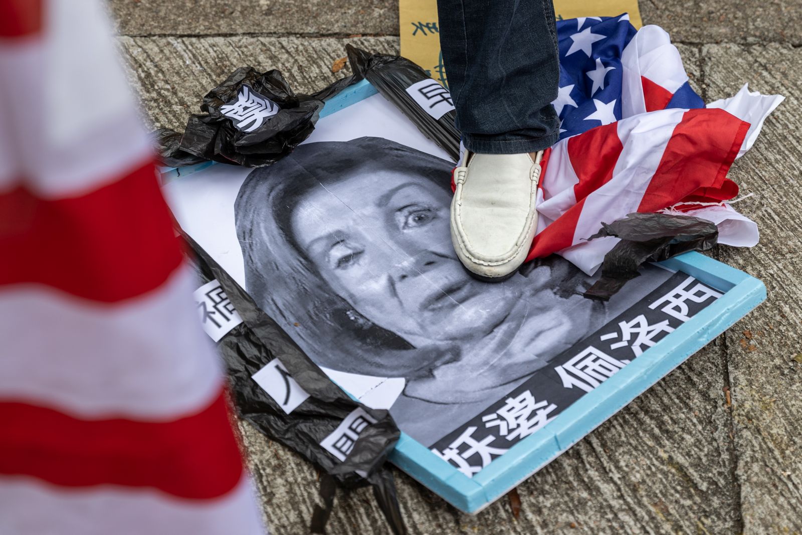 epaselect epa10103683 A group of pro-China supporters steps on a mock up funeral photo of US House Speaker Nancy Pelosi outside of the US Consulate General in Hong Kong and Macau, in Hong Kong, China, 03 August 2022. The group protested the visit to Taiwan by Nancy Pelosi who is leading a Congressional delegation to the Indo-Pacific region with stops in Singapore, Malaysia, South Korea and Japan.  EPA/JEROME FAVRE