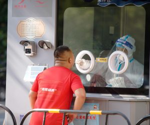 epaselect epa10107009 A medical worker takes a swab sample from a man to be tested for COVID-19 at a swab collection site in Beijing, China, 05 August 2022. According to the National Health Commission's report on 05 August, 162 new locally transmitted COVID-19 cases were detected in mainland China, of which 127 were in Hainan. Local Authorities implemented tighter COVID-19 curbs in most parts of Sanya city by imposing mass testing and closing major tourism spots in the city.  EPA/WU HAO