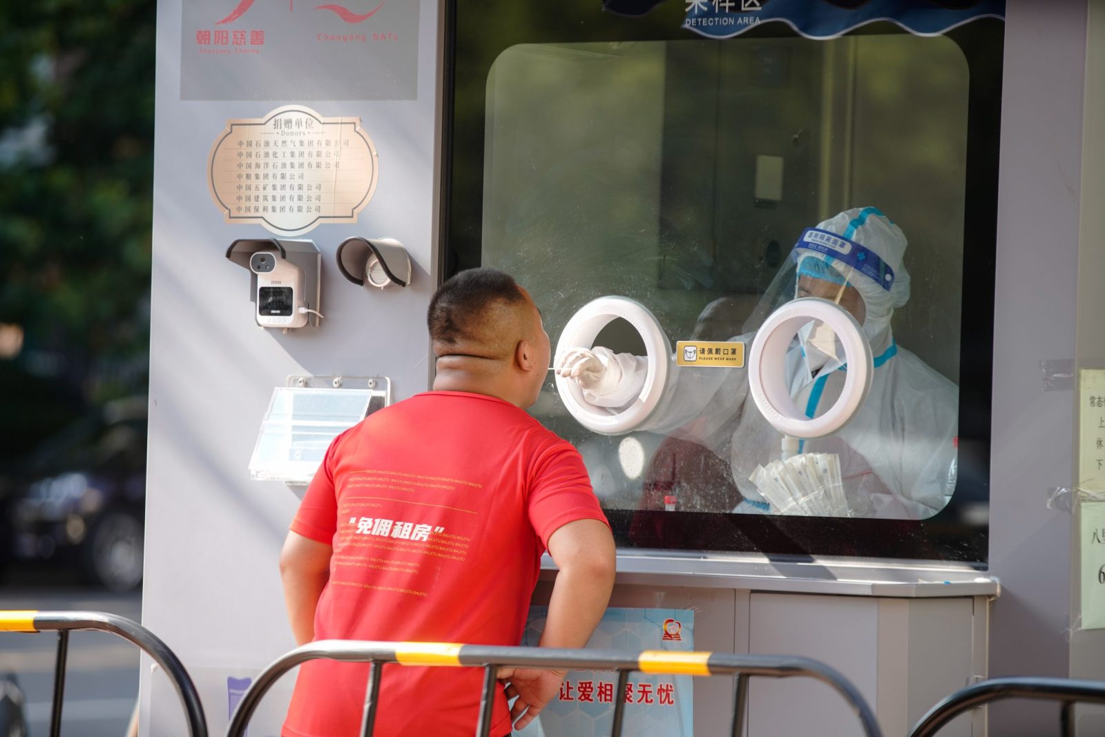 epaselect epa10107009 A medical worker takes a swab sample from a man to be tested for COVID-19 at a swab collection site in Beijing, China, 05 August 2022. According to the National Health Commission's report on 05 August, 162 new locally transmitted COVID-19 cases were detected in mainland China, of which 127 were in Hainan. Local Authorities implemented tighter COVID-19 curbs in most parts of Sanya city by imposing mass testing and closing major tourism spots in the city.  EPA/WU HAO