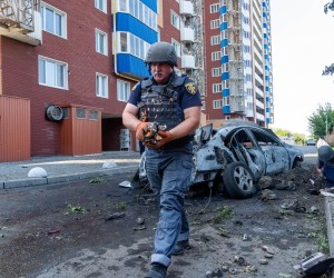 Harkiv, Ukrajina, 08.08.2022. - Službenik Ukrajinske državne službe za hitne slučajeve skuplja fragmente glave MLRS-a, čiji je projektil eksplodirao u blizini stambene zgrade u Harkivu. U eksploziji je smrtno stradala jedna osoba. Rusija napada Ukrajinu. foto HINA/ (mr) PAP/Mykola Kalyeniak/ ml