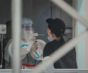 epa10139458 A woman undergoes a COVID-19 test at the Beijing Capital International Airport in Beijing, China, 26 August 2022. US will suspend 26 flights from Chinese carriers going to China as a response to the Chinese government's decision to suspend US carrier flights over COVID-19 cases.  EPA/MARK R. CRISTINO