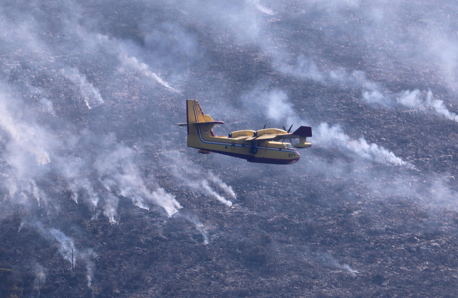 19.08.2021., Hvar - U pomoc vatrogascima stigli su i kanaderi koji gase pozar koji je nocas buknuo na Hvaru kod Starog Grada na rtu Kabal. Vatrogasci kazu da vatrena stihija ne ugrozava stambene objekte, a ocekuje se da ce biti lokaliziran tijekom dana. rPhoto: Ivo Cagalj/PIXSELL