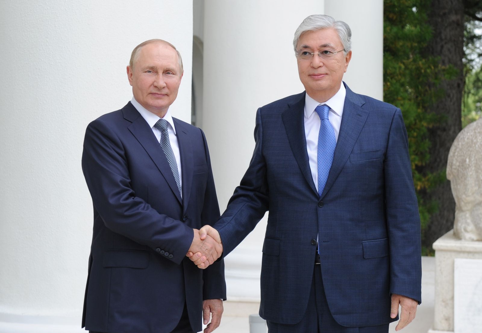 epa10129175 Russian President Vladimir Putin (L) and Kazakh President Kassym-Jomart Tokayev (R) shake hands during a meeting in the Black sea resort of Sochi, Russia, 19 August 2022. Kazakhstan's President is on a working visit in Sochi.  EPA/NIKITA ORLOV / KREMLIN POOL / SPUTNIK MANDATORY CREDIT