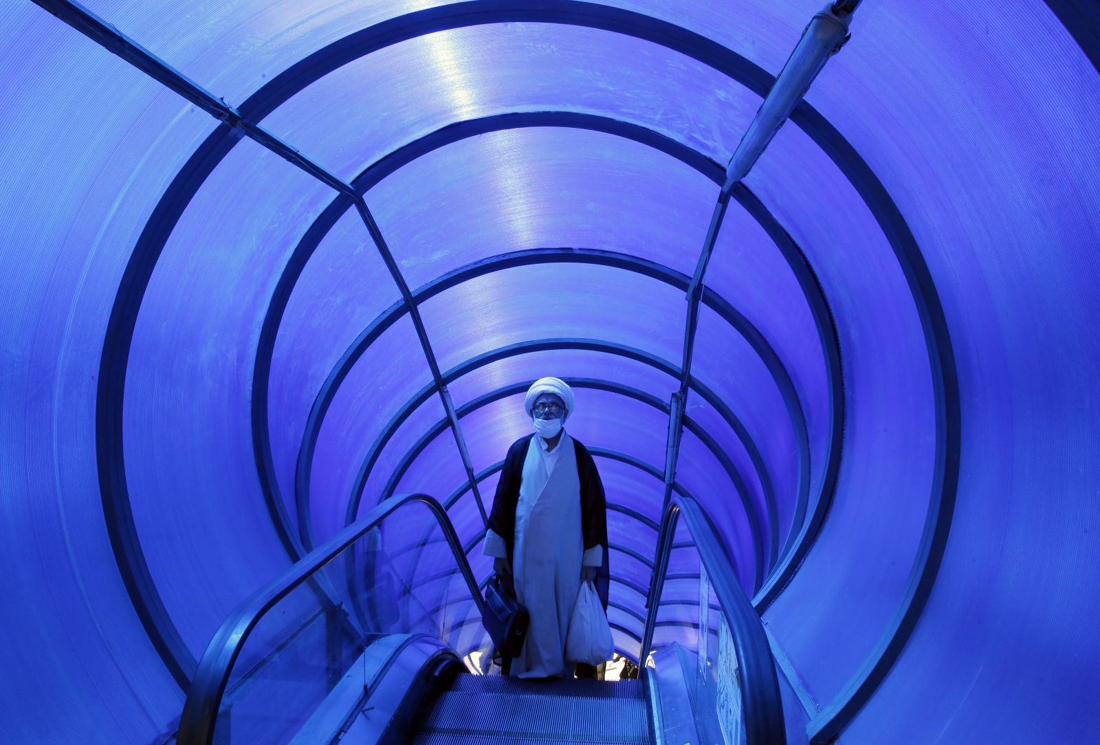 epaselect epa10137520 An Iranian cleric takes pedestrian bridge elevator in a street in Tehran, Iran, 25 August 2022. According to Iranian foreign ministry, Iran has received US answer to its nuclear deal on 24 August 2022. The ministry also reported that Tehran will respond to US and EU soon. Iran has responded on 16 August 2022 officially to top European Union proposal aimed at salvaging 2015 nuclear deal with world powers, and was waiting for US and EU response. Iran is facing economic crisis over sanctions by US and EU.  EPA/ABEDIN TAHERKENAREH
