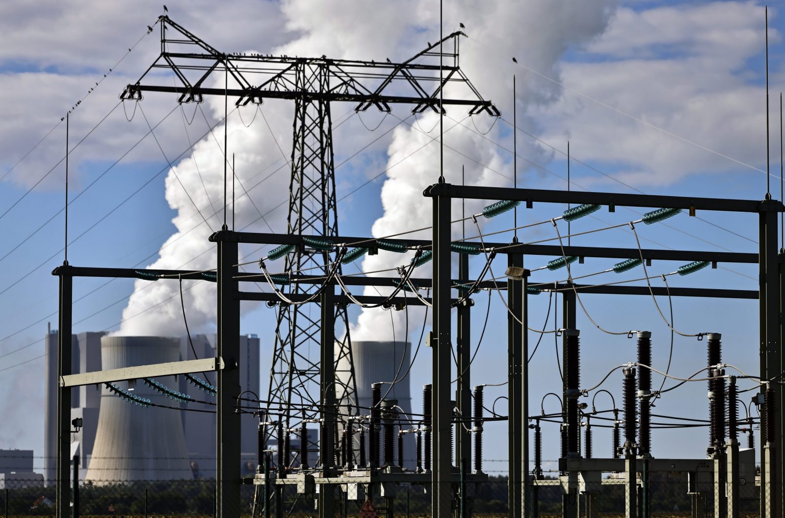 epa10154273 A power pole in front of the cooling towers of Schwarze Pumpe power station in Spremberg, Brandenburg, Germany, 02 September 2022. German Chancellor Scholz is visiting the Lusatia region in eastern Germany, one of the largest mining areas in the country, to meet the heads of the federal states of the coal regions affected by structural change.  EPA/HANNIBAL HANSCHKE
