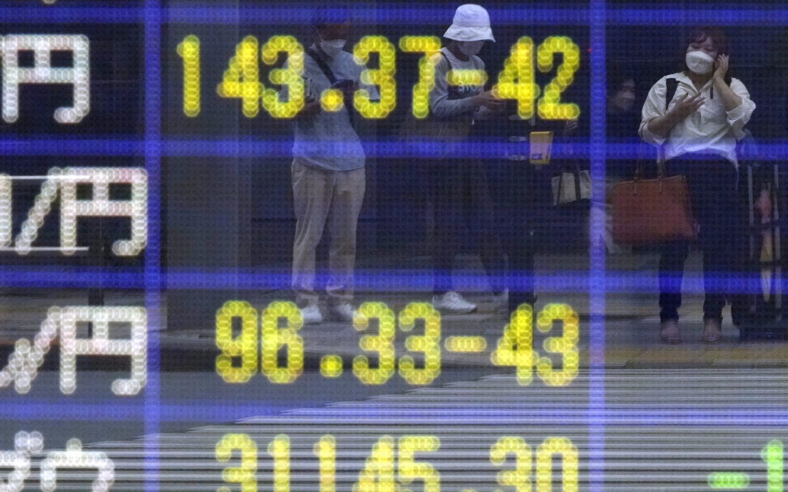 epa10166194 Passersby are reflected on a screen displaying the Japanese yen exchange rate against the US dollar (top) in Tokyo, Japan, 07 September 2022. The yen continues its fall against the US dollar to reach a new 24-year low.  EPA/FRANCK ROBICHON