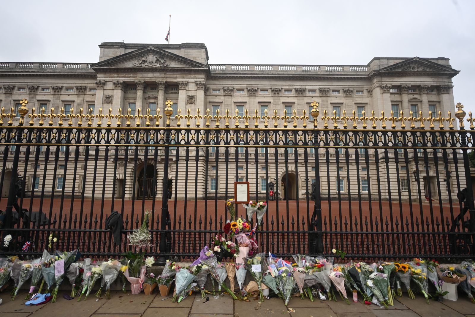 epa10172528 Floral tributes outside the railings of Buckingham Palace a day after the passing of Queen Elizabeth II, in London, Britain, 09 September 2022. Britain's Queen Elizabeth II died at her Scottish estate on 08 September 2022. The 96-year-old queen was the longest-reigning monarch in British history.  EPA/NEIL HALL