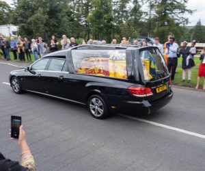 epa10177899 People stand to pay their respects as the hearse carrying the body of Queen Elizabeth II makes its way towards Edinburgh, in Dundee, Scotland, Britain, 11 September 2022. Britain's Queen Elizabeth II died at her Scottish estate on 08 September. The late queen will lie in state for 24 hours at St Giles' Cathedral in Edinburgh.  EPA/PAUL REID