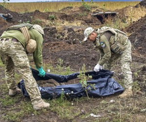 epa10188478 Ukrainian soldiers, members of a special evacuation team, exhume the body of a Ukrainian National Guard soldier who was killed in fighting in the first days of Russia's invasion, near the urban settlement Kazachya Lopan, north of Kharkiv, northeastern Ukraine, 16 September 2022. The Ukrainian army pushed Russian troops from occupied territory in the northeast of the country in a counterattack. Kharkiv and surrounding areas have been the target of heavy shelling since February 2022, when Russian troops entered Ukraine starting a conflict that has provoked destruction and a humanitarian crisis.  EPA/SERGEY KOZLOV -- ATTENTION EDITORS: GRAPHIC CONTENT