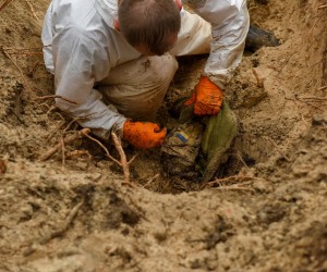 epa10188573 A forensic technician inspects inspects a body in a grave near Izyum, Kharkiv region, northeastern Ukraine, 16 September 2022. A mass burial site was found after Ukrainian troops recaptured the town of Izyum. According to the head of the investigative department of the police of the Kharkiv region, the burial site, one of the largest in a recaptured city so far, counts more than 440 separate graves. The Ukrainian army pushed Russian troops from occupied territory in the northeast of the country in a counterattack. Kharkiv and surrounding areas have been the target of heavy shelling since February 2022, when Russian troops entered Ukraine starting a conflict that has provoked destruction and a humanitarian crisis.  EPA/OLEG PETRASYUK -- ATTENTION EDITORS: GRAPHIC CONTENT