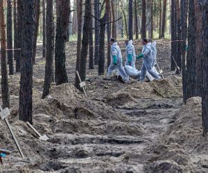 epa10194312 Ukrainian workers carry a body that was unearthed from graves in Izyum, Kharkiv region, northeastern Ukraine, 19 September 2022. A mass burial site was found after Ukrainian troops recaptured the town of Izyum. According to the head of the investigative department of the police of the Kharkiv region, the burial site, one of the largest in a recaptured city so far, counts more than 440 separate graves. The Ukrainian army pushed Russian troops from occupied territory in the northeast of the country in a counterattack. Kharkiv and surrounding areas have been the target of heavy shelling since February 2022, when Russian troops entered Ukraine starting a conflict that has provoked destruction and a humanitarian crisis.  EPA/SERGEY KOZLOV