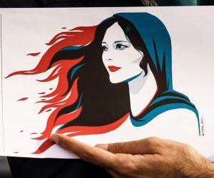 epa10201920 A participant holds an illustration showing Mahsa Amini during a rally in Berlin, Germany, 23 September 2022. Iran has faced many anti-government protests following the death of Mahsa Amini, a 22-year-old Iranian woman, who was arrested in Tehran on 13 September by the morality police, a unit responsible for enforcing Iran's strict dress code for women. She fell into a coma while in police custody and was declared dead on 16 September, with the authorities saying she died of a heart failure while her family advising that she had no prior health conditions. Her death has triggered protests in various areas in Iran and around the world. According to Iran's state news agency IRNA, Iranian President Ebrahim Raisi expressed his sympathy to the family of Amini on a phone call and assured them that her death will be investigated carefully. Chief Justice of Iran Gholam-Hossein Mohseni-Eje'i assured her family that upon its conclusion, the investigation results by the Iranian Legal Medicine Organization will be announced without any special considerations.  EPA/CLEMENS BILAN