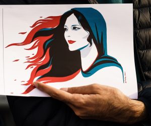 epa10201920 A participant holds an illustration showing Mahsa Amini during a rally in Berlin, Germany, 23 September 2022. Iran has faced many anti-government protests following the death of Mahsa Amini, a 22-year-old Iranian woman, who was arrested in Tehran on 13 September by the morality police, a unit responsible for enforcing Iran's strict dress code for women. She fell into a coma while in police custody and was declared dead on 16 September, with the authorities saying she died of a heart failure while her family advising that she had no prior health conditions. Her death has triggered protests in various areas in Iran and around the world. According to Iran's state news agency IRNA, Iranian President Ebrahim Raisi expressed his sympathy to the family of Amini on a phone call and assured them that her death will be investigated carefully. Chief Justice of Iran Gholam-Hossein Mohseni-Eje'i assured her family that upon its conclusion, the investigation results by the Iranian Legal Medicine Organization will be announced without any special considerations.  EPA/CLEMENS BILAN