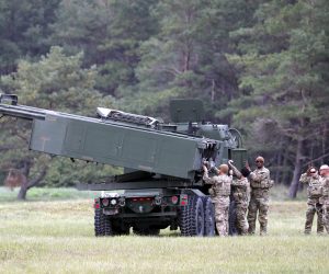 epa10207730 U.S. servicemen with their light multiple rocket launcher M142 High Mobility Artillery Rocket System (HIMARS) attend the military exercise 'Namejs 2022' at Skede polygon near Liepaja, Latvia, 26 September 2022. The goal of this exercise is to demonstrate the effective multicomponent cooperation between the National Armed Forces and the US Armed Forces, with Latvian side discovering, identifying and evaluating the targets, and the allies providing the requested assistance and completing the mission objective.  EPA/TOMS KALNINS