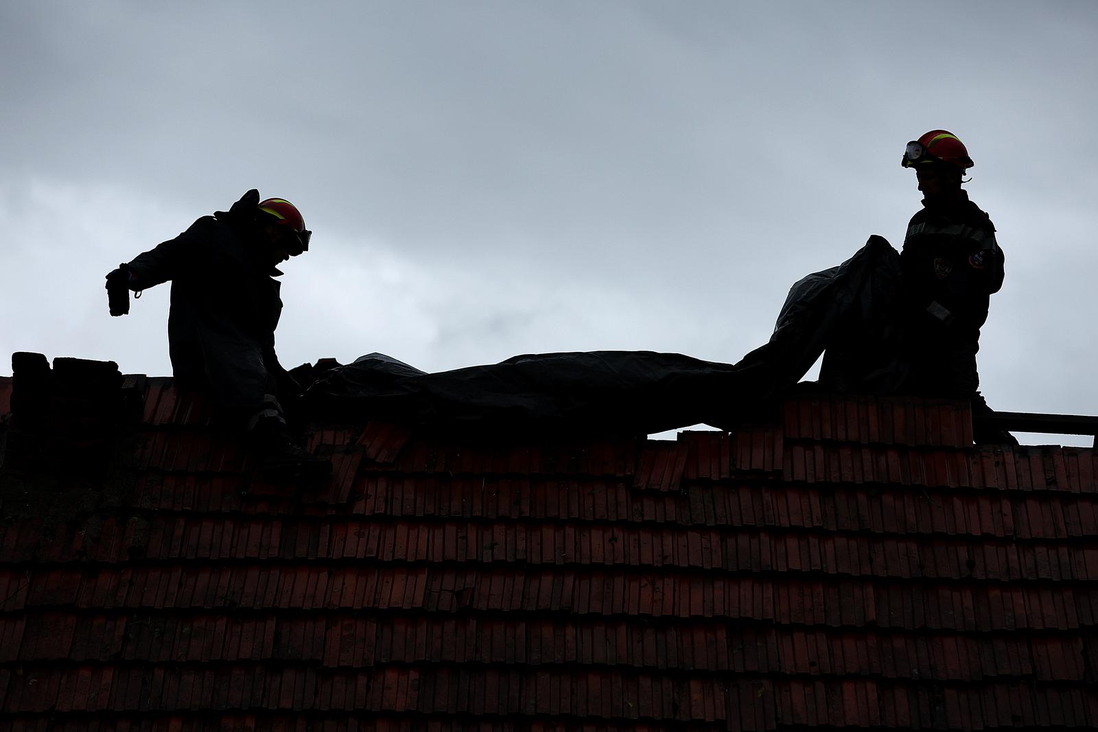 16.09.2022., Bosiljevo - Posljedice nevremena u Cazmi vidljive su na svakom koraku. Mnoge kuce u Cazmi ostale su bez krovova, a dijelovi krovova i crijepovi ostali su razbacani uokolo. Vatrogasci popravljaju krov jedne od unistenih kuca Photo: Goran Stanzl/PIXSELL