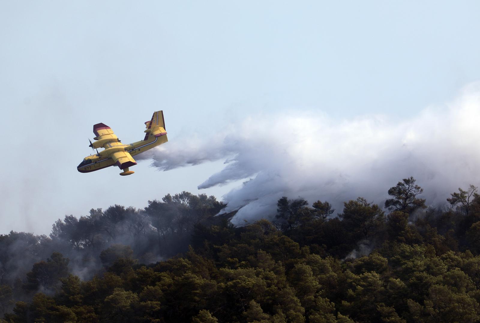 19.08.2021., Hvar - U pomoc vatrogascima stigli su i kanaderi koji gase pozar koji je nocas buknuo na Hvaru kod Starog Grada na rtu Kabal. Vatrogasci kazu da vatrena stihija ne ugrozava stambene objekte, a ocekuje se da ce biti lokaliziran tijekom dana. rPhoto: Ivo Cagalj/PIXSELL