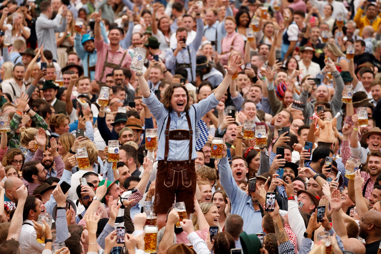 A visitor cheers after finishing a mug of beer during the official opening the world's largest beer festival, the 187th Oktoberfest in Munich, Germany, September 17, 2022. REUTERS/Michaela Rehle     TPX IMAGES OF THE DAY Photo: Michaela Rehle/REUTERS