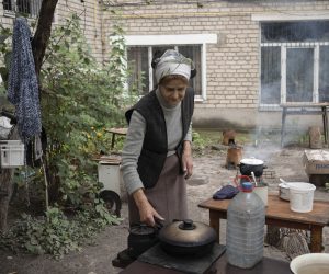 epa10188671 Maria, 82, cooks food over an open fire as gas and electricity are not available, near a residential building in the recently recaptured city of Izyum, Kharkiv region, northeastern Ukraine, 16 September 2022, amid Russia's invasion. The Ukrainian army pushed Russian troops from occupied territory in the northeast of the country in a counterattack. Kharkiv and surrounding areas have been the target of heavy shelling since February 2022, when Russian troops entered Ukraine starting a conflict that has provoked destruction and a humanitarian crisis.  EPA/ANASTASIA VLASOVA