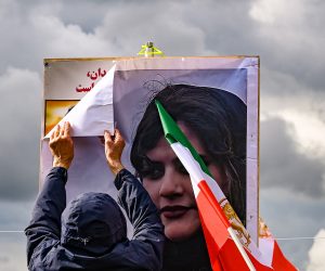 epa10211353 A participant prepares posters of Mahsa Amini during a rally in front of the Reichstag building in Berlin, Germany, 28 September 2022. Iran has been facing many anti-government protests following the death of Mahsa Amini, a 22-year-old Iranian woman, who was arrested in Tehran on 13 September by the morality police, a unit responsible for enforcing Iran's strict dress code for women and died while in their custody.  EPA/FILIP SINGER