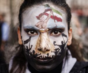 epa10219686 A woman with her face painted participates in a rally in support of Iranian women in Paris, France, 02 October 2022. This demonstration takes place following the deaths of Mahsa Amini, who died while in police custody after being detained by Iran's morality police, and Hadis Najafi, who was shot during a protest in Iran.  EPA/YOAN VALAT