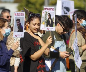 epa10222797 People hold placards during a demonstration in solidarity with the Iranian people near the European Parliament in Strasbourg, France, 04 October 2022. Mahsa Amini's death, a 22-year-old girl who was detained on 13 September by the police unit responsible for enforcing Iran's strict dress code, has led to protests around the world.  EPA/JULIEN WARNAND