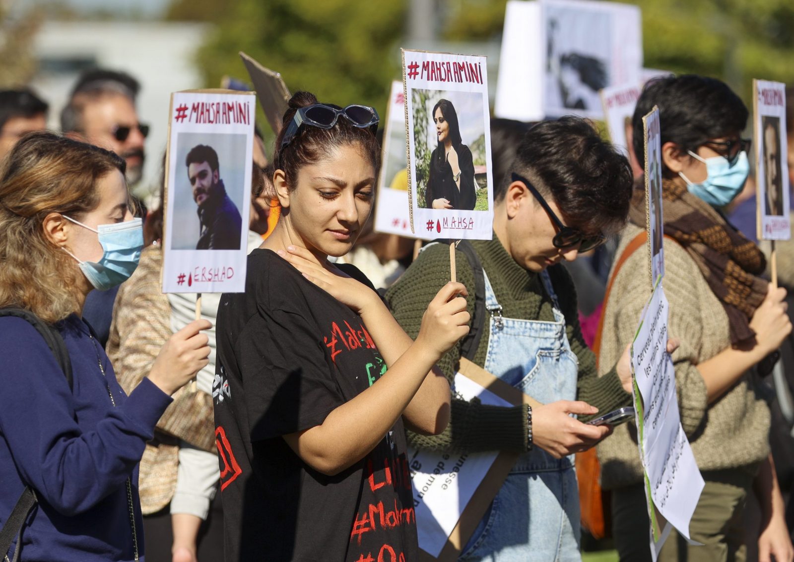 epa10222797 People hold placards during a demonstration in solidarity with the Iranian people near the European Parliament in Strasbourg, France, 04 October 2022. Mahsa Amini's death, a 22-year-old girl who was detained on 13 September by the police unit responsible for enforcing Iran's strict dress code, has led to protests around the world.  EPA/JULIEN WARNAND