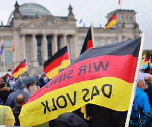 epa10230595 A German national flag with 'We are the people' inscription as protesters demonstrate in front of Reichstags building in Berlin, Germany, 08 October 2022. The right-wing populist Alternative for Germany (Alternative fuer Deutschland, AfD) party called for a demonstration against rising prices.  EPA/HANNIBAL HANSCHKE