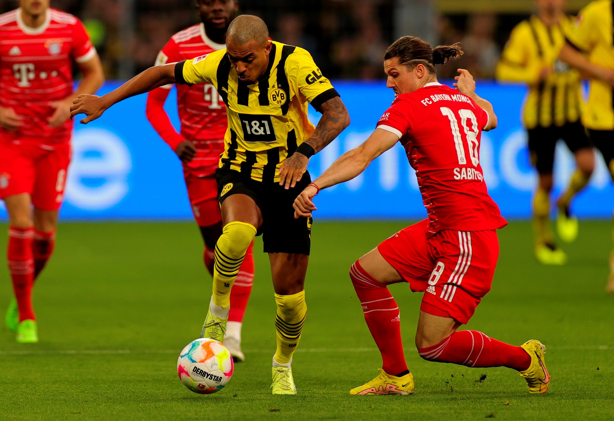 epa10231143 Dortmund's Donyell Malen (C) in action against Bayern's Marcel Sabitzer (R) during the German Bundesliga soccer match between Borussia Dortmund and Bayern Munich in Dortmund, Germany, 08 October 2022.  EPA/FRIEDEMANN VOGEL CONDITIONS - ATTENTION: The DFL regulations prohibit any use of photographs as image sequences and/or quasi-video.