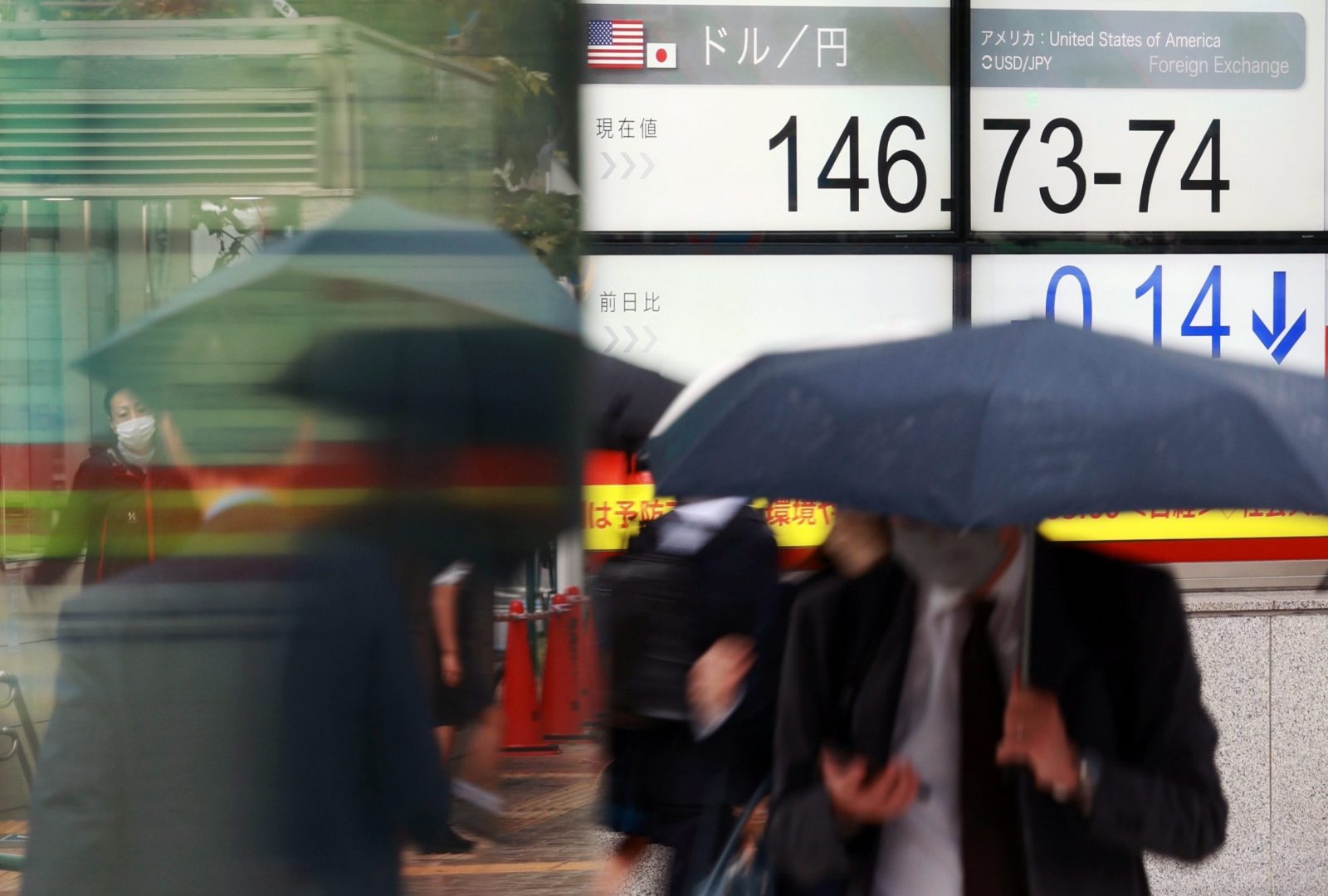 epa10240037 Pedestrians walk past a screen displaying the Japanese yen exchange rate against the US dollar in Tokyo, Japan, 13 October 2022. The yen fell against the US dollar to reach the upper 146 range.  EPA/JIJI PRESS JAPAN OUT EDITORIAL USE ONLY/