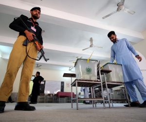 epa10246926 A police officer stands guard as a man casts his ballot at a polling station during by-elections in Peshawar, Khyber Pakhtunkhwa province, Pakistan, 16 October 2022.Polling for by-elections on eight seats of National Assembly and three seats of Punjab Assembly is underway. Imran Khan, former Prime Minister and head of the opposition political party Pakistan Tehrik-e-Insaf, is running to defend his seven constituencies of National Assembly seats.  EPA/ARSHAD ARBAB
