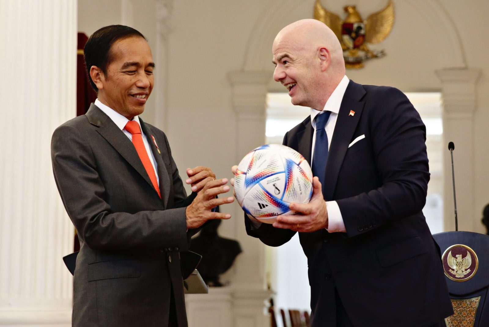 epa10250031 Indonesian President Joko Widodo (L) receives a ball from President of Federation Internationale de Football Association (FIFA) Gianni Infantino during their meeting at Presidential Palace in Jakarta, Indonesia, 18 October 2022. Infantino visits Indonesia to discuss the national football transformation especially after the Kanjuruhan tragedy on 01 October 2022 which left 132 dead and hundreds were injured.  EPA/ADI WEDA