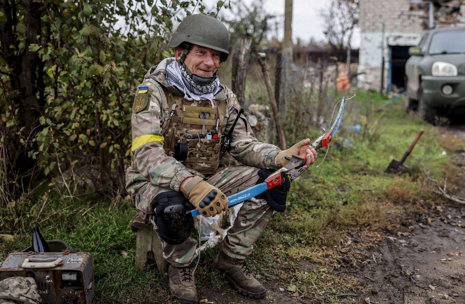 epa10264733 A Ukrainian soldier smiles with a crossbow he found during search for explosives at a recapture area in the north of Kherson, Ukraine, 25 October 2022. Russian troops on 24 February entered Ukrainian territory, starting a conflict that has provoked destruction and a humanitarian crisis.  EPA/HANNIBAL HANSCHKE