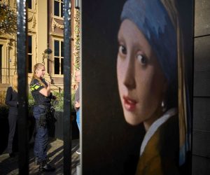 epa10269111 A police officer (L) stands outside the Mauritshuis museum, where three people were arrested for attempting to smudge Vermeer's painting 'Girl with a Pearl Earring', currently exhibited there, in The Hague, Netherlands, 27 October 2022. They were wearing shirts from the Just Stop Oil campaign group, whose members are responsible for recent acts of vandalism - such as throwing soup at paintings, sports cars and luxury shop windows across Europe - in an attempt to raise awareness about their protest against fossil fuels.  EPA/PHIL NIJHUIS