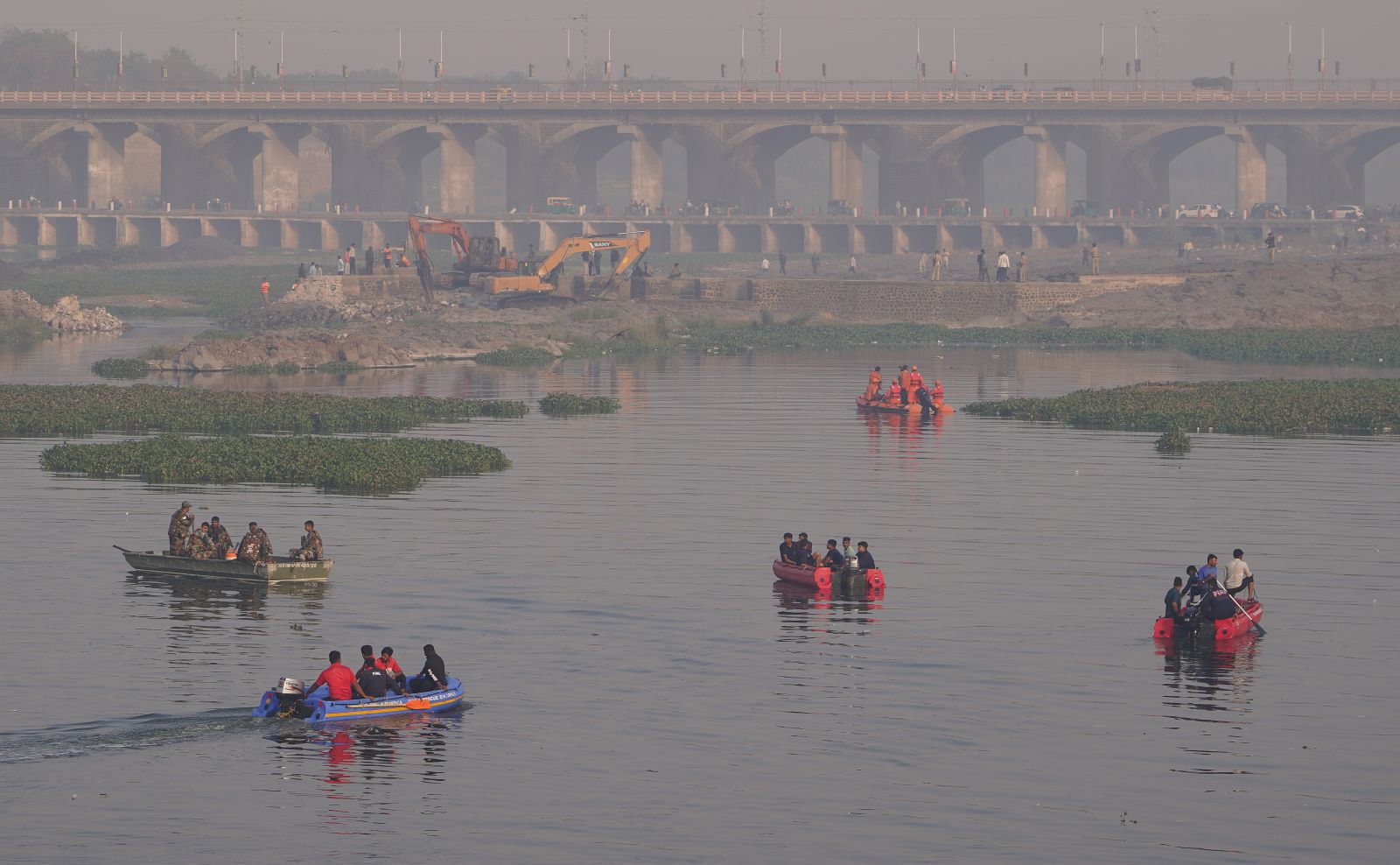 epa10276385 National Disaster Response Force (NDRF) police and miltary personnel work at the site after a 100-year-old suspension bridge collapsed in Morbi, Gujarat, India, 31 October 2022. According to the police officials in Gujarat, at least 130 people have been reported dead in the incident and police, military and disaster response teams were deployed for the continuing rescue operations.  EPA/SIDDHARAJ SOLANKI