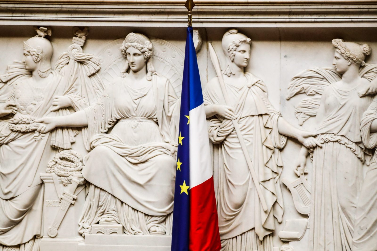 epa10263410 French and an EU flags at the National Assembly in Paris, France, 24 October 2022. The left-wing parliamentary groups of the 'Nupes' coalition (New Popular Ecological and Social Union) and far right-wing deputies of RN (Rassemblement National) have tabled each one a motion of censure against the government of Prime Minister Elisabeth Borne after the application of Article 49 paragraph 3 of the Constitution to vote the state budget.  EPA/TERESA SUAREZ