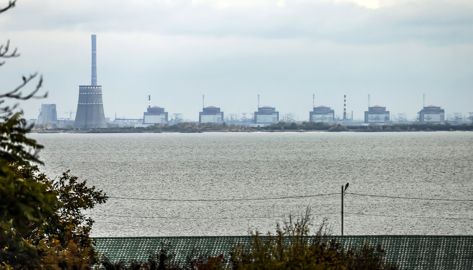 epa10271118 The Zaporizhzhia nuclear power plant (ZNPP) is seen from Nikopol, Ukraine, 28 October 2022. According to a statement by IAEA director general chief Grossi from 28 October 2022, engineers at the ZNPP have been working to stabilize the facility’s external power supplies. The plant has received the power needed to cool the reactors "directly and without interruption from the national grid," the nuclear watchdog's chief said. Russian troops on 24 February entered Ukrainian territory, starting a conflict that has provoked destruction and a humanitarian crisis.  EPA/HANNIBAL HANSCHKE